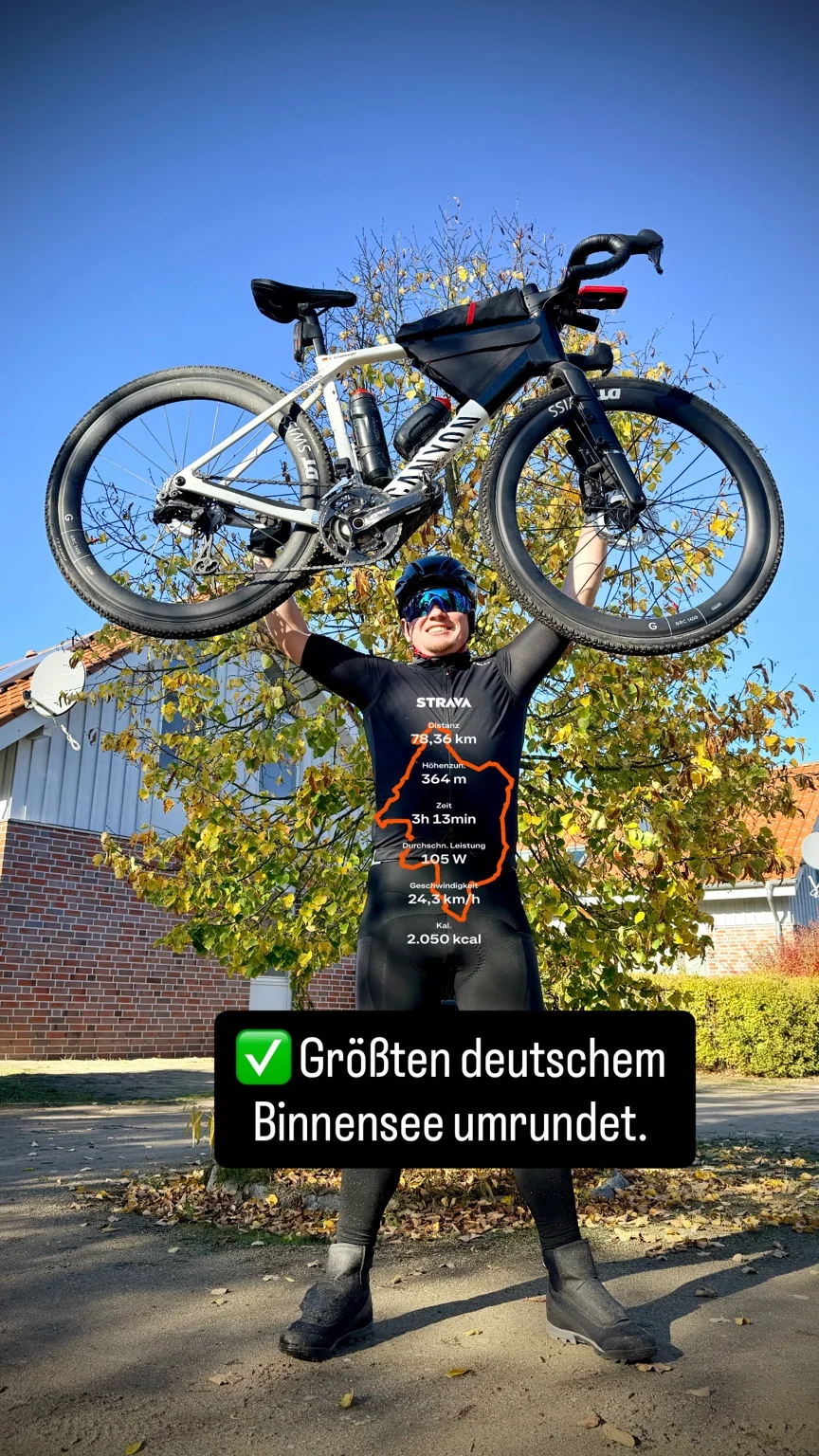 Rainer hebt sein Fahrrad nach einer Tour am See über den Kopf